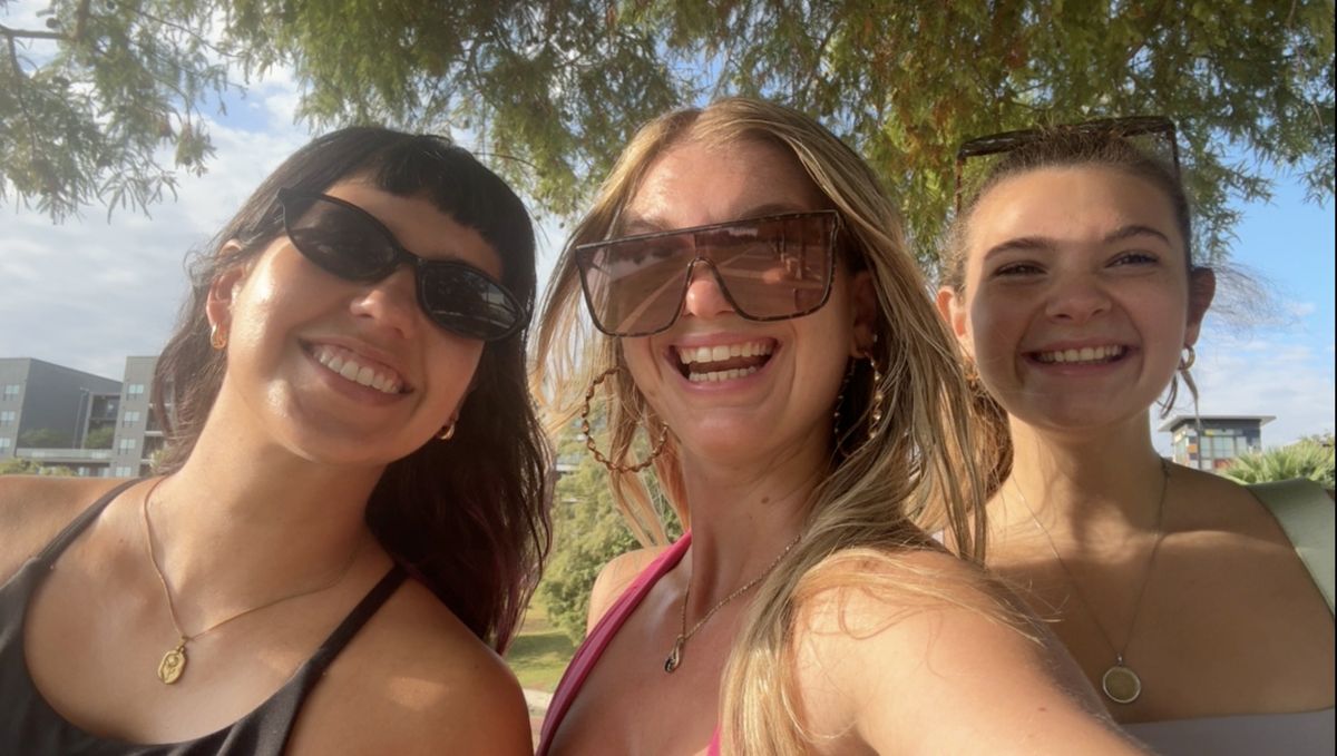 Three walkers smiling in a selfie under the trees