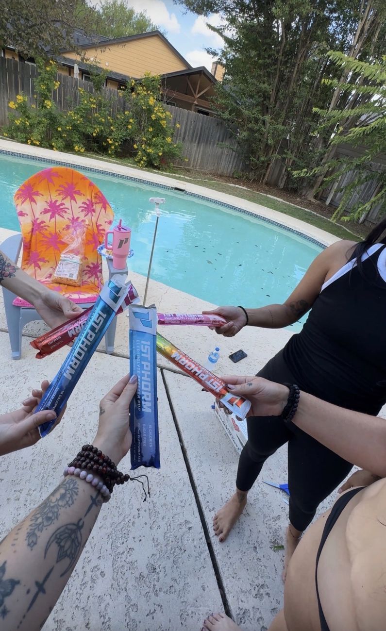 Friends toasting with 1st Phorm electrolyte freezer pops by the pool